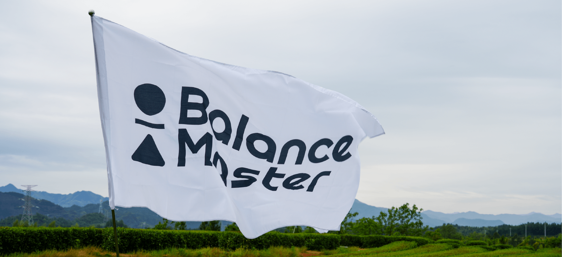Balance Master flag waving above tea fields